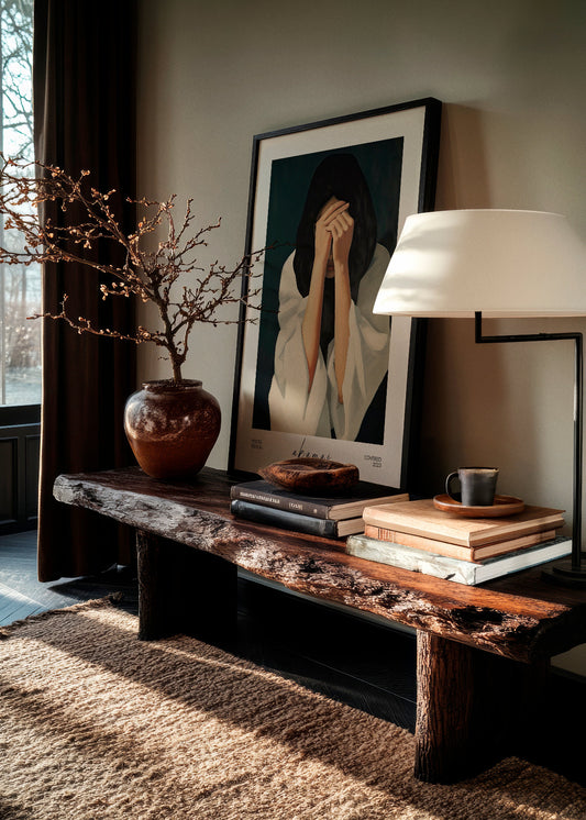 Covered poster from the Akamai Poster Edition in collaboration with HelloPoster, styled in a Scandinavian interior with rustic wooden bench, books, and soft lighting.