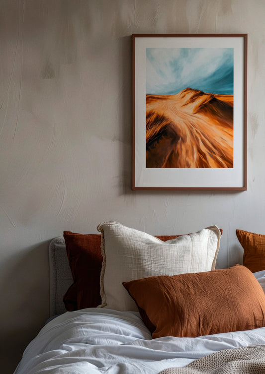 Dune poster by Hello Poster featuring golden sand dunes under a blue sky, displayed in a modern bedroom with neutral tones and warm textiles
