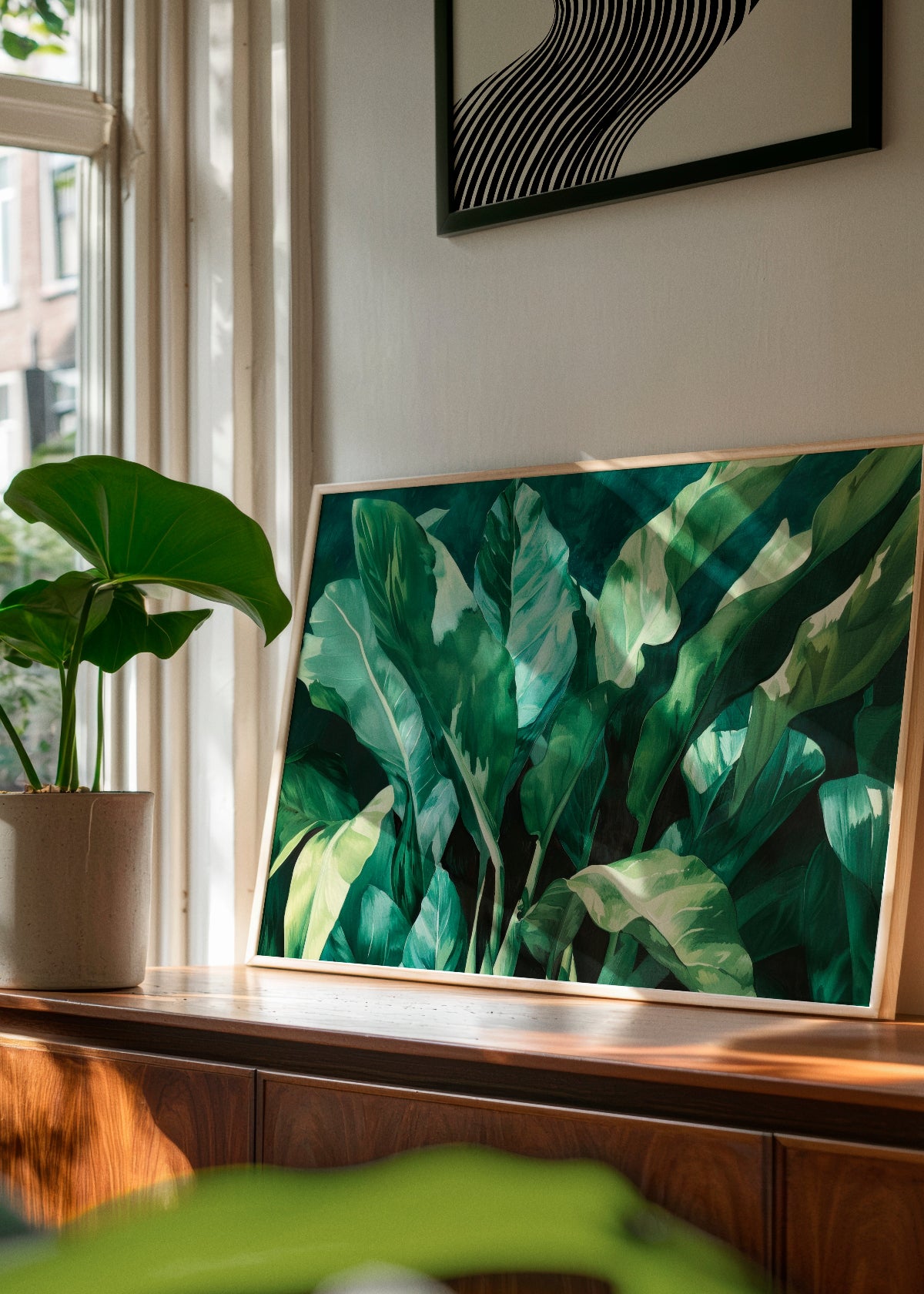Plant poster leaning against a wall in a sunlit space – A lush botanical print adding a fresh, natural vibe to a modern home with wooden and earthy tones.