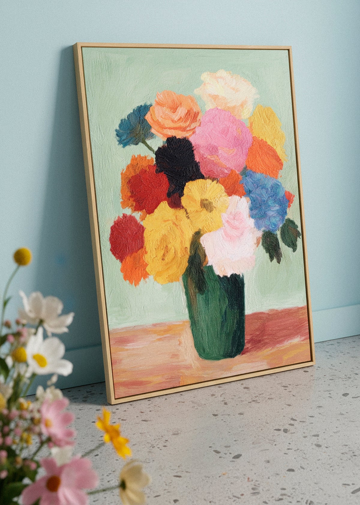 Colorful Blossoms canvas print leaning on the floor beside fresh spring flowers. Floral artwork with vibrant brushstrokes and green vase. Calm, bright interior setting. HelloPoster canvas artwork.