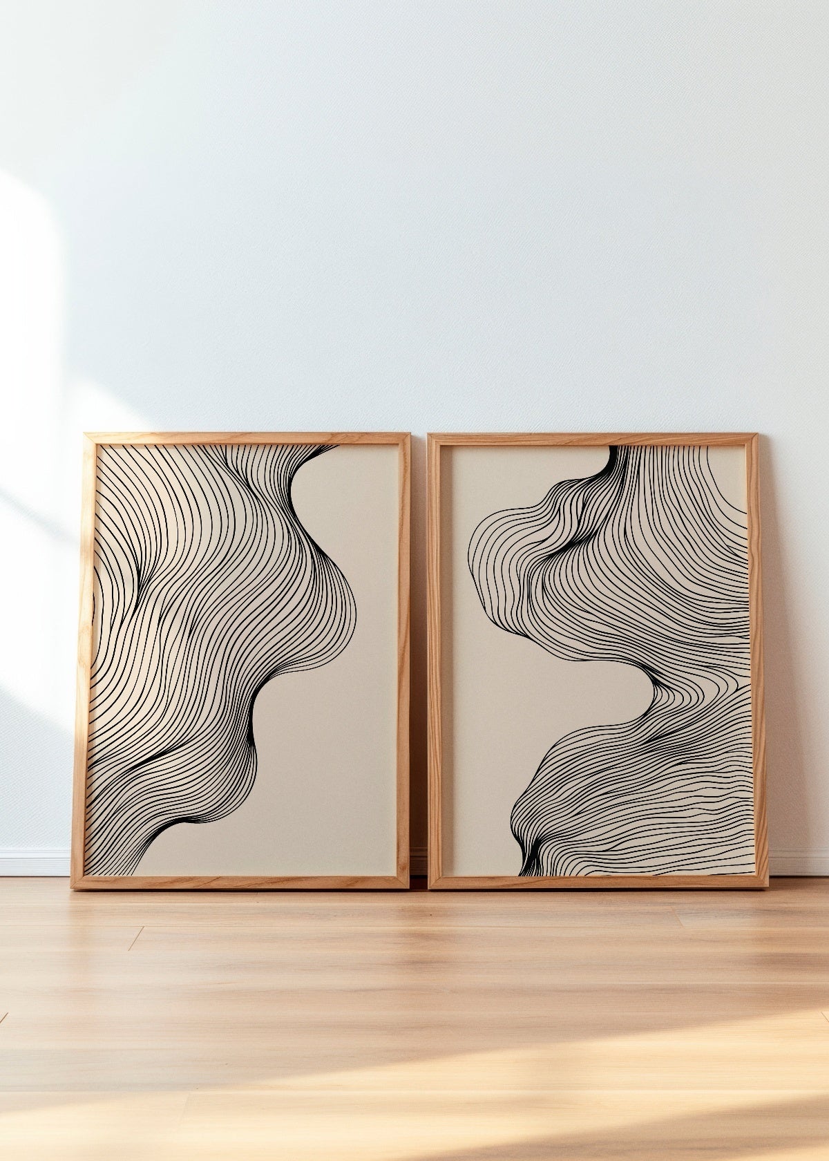 Elegant black and beige line art posters Miles and Tate displayed in wooden frames. The abstract fluid design creates a minimalist and modern aesthetic, perfect for contemporary interiors. A stylish choice for those who appreciate simplicity and organic shapes in home decor.