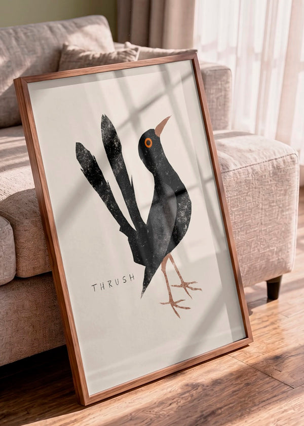 Elegant Black Thrush plakat af Josephin Hermsdorf i træramme, stylet op ad en lys sofa i et varmt, nordisk interiør med naturligt sollys.