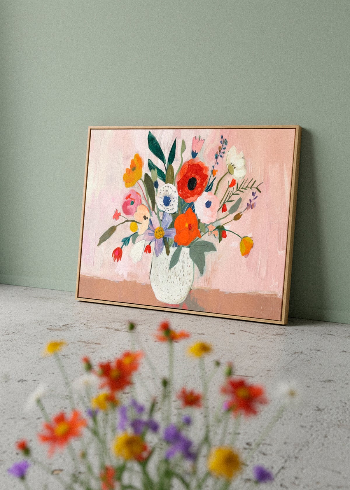Flowers canvas print by Hello Poster with a bold floral bouquet and pink background, styled against a muted green wall with blurred flowers in the foreground.