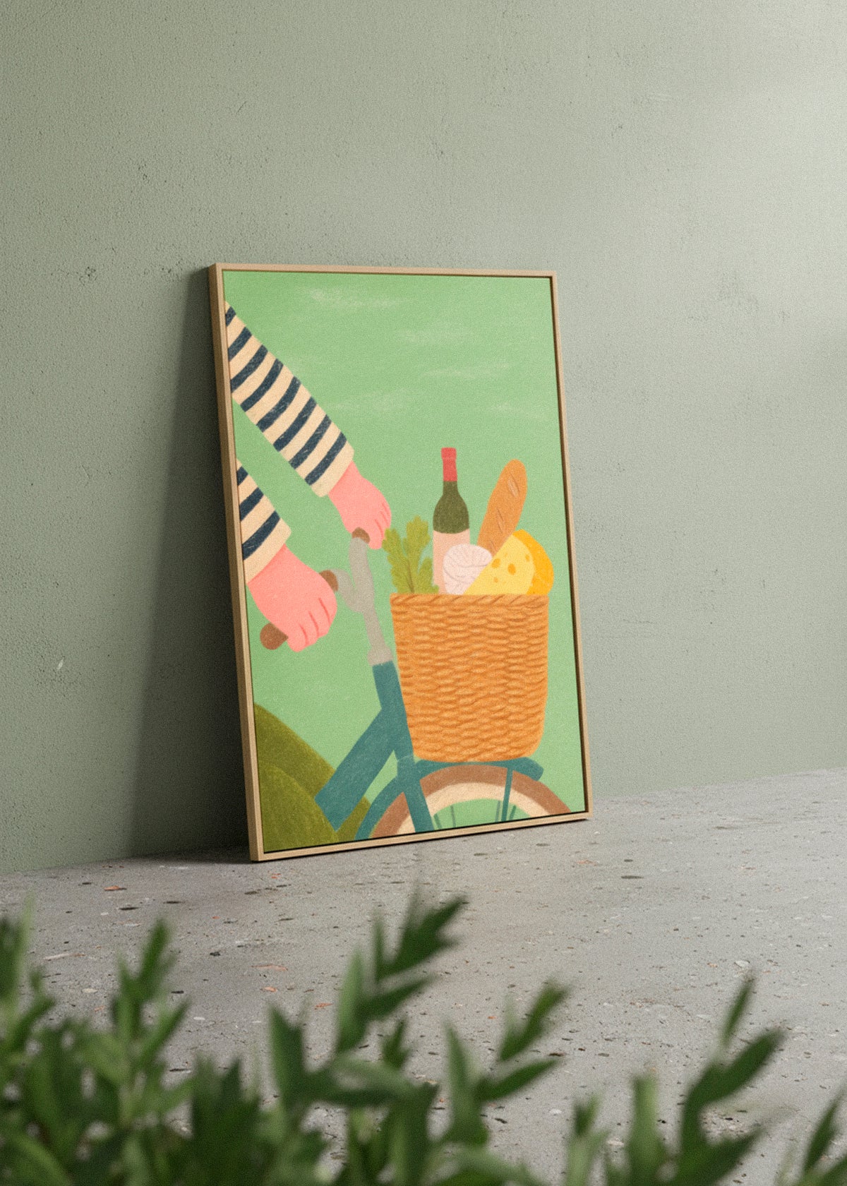 French Picnic canvas print leaning against a green wall, showing a bicycle with a basket of picnic essentials – Hello Poster