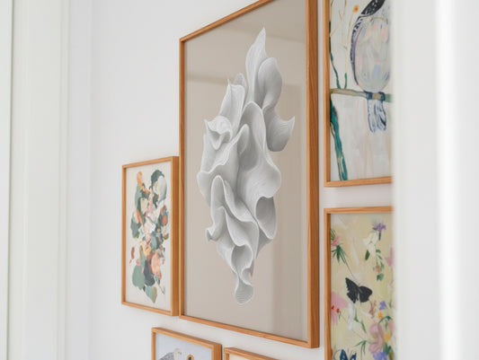 Close-up of a Scandinavian gallery wall showing a large white abstract poster beside botanical and bird-themed designs in oak frames.
