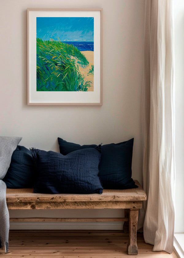 Lime Grass poster in a Scandinavian living room with natural wood bench and soft neutral tones, featuring vibrant green grass, sandy beige and deep blue ocean colors