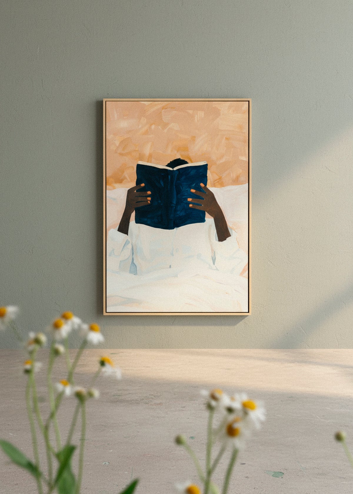 Framed “Must Read” canvas print hanging above a cozy bed with neutral bedding and natural light filtering through curtains.