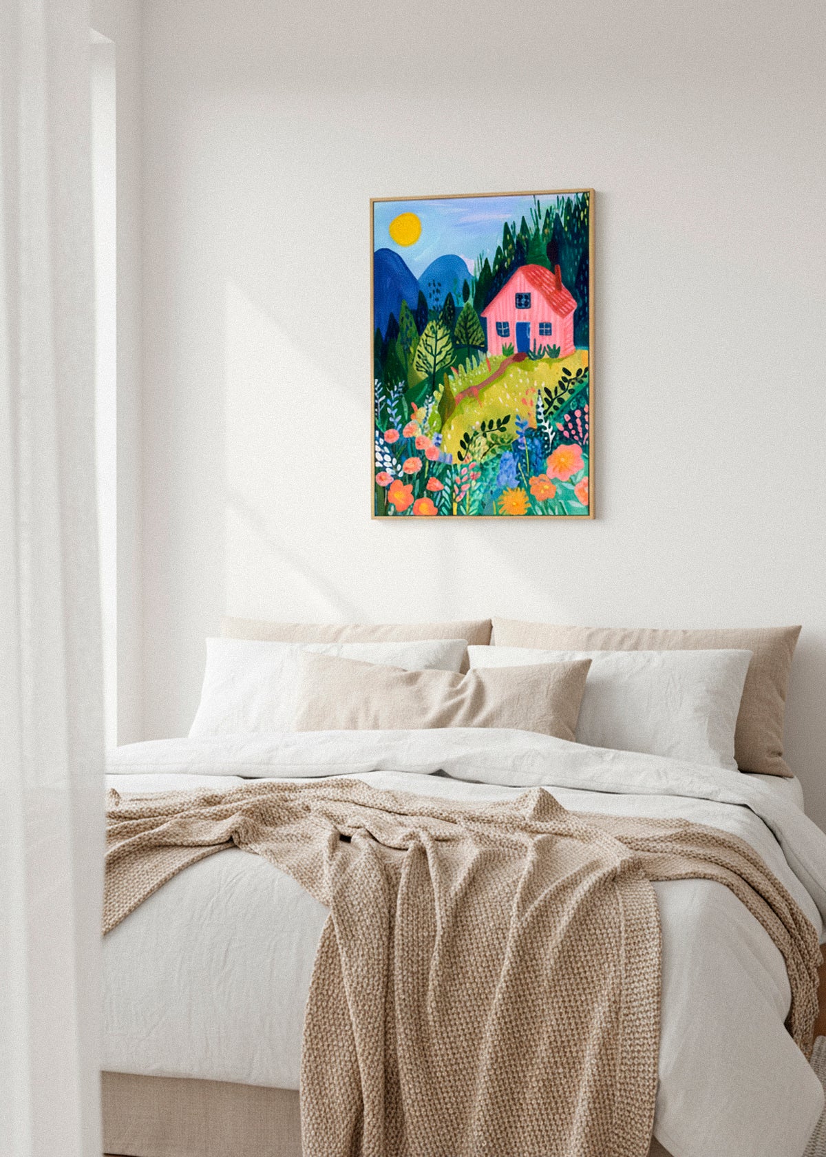 Framed “Pink House” canvas print hanging above a cozy bed with neutral tones and sunlight filtering through curtains.