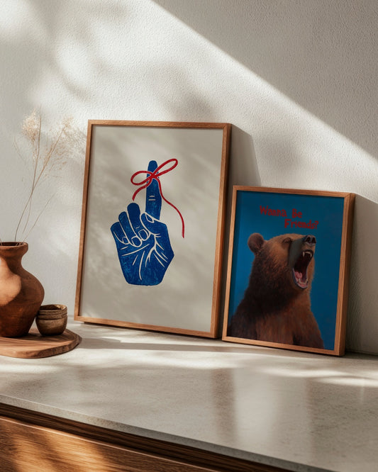Whimsical 'Boy Bear' and bold 'Remember' posters styled together on a light-toned shelf with warm shadows.