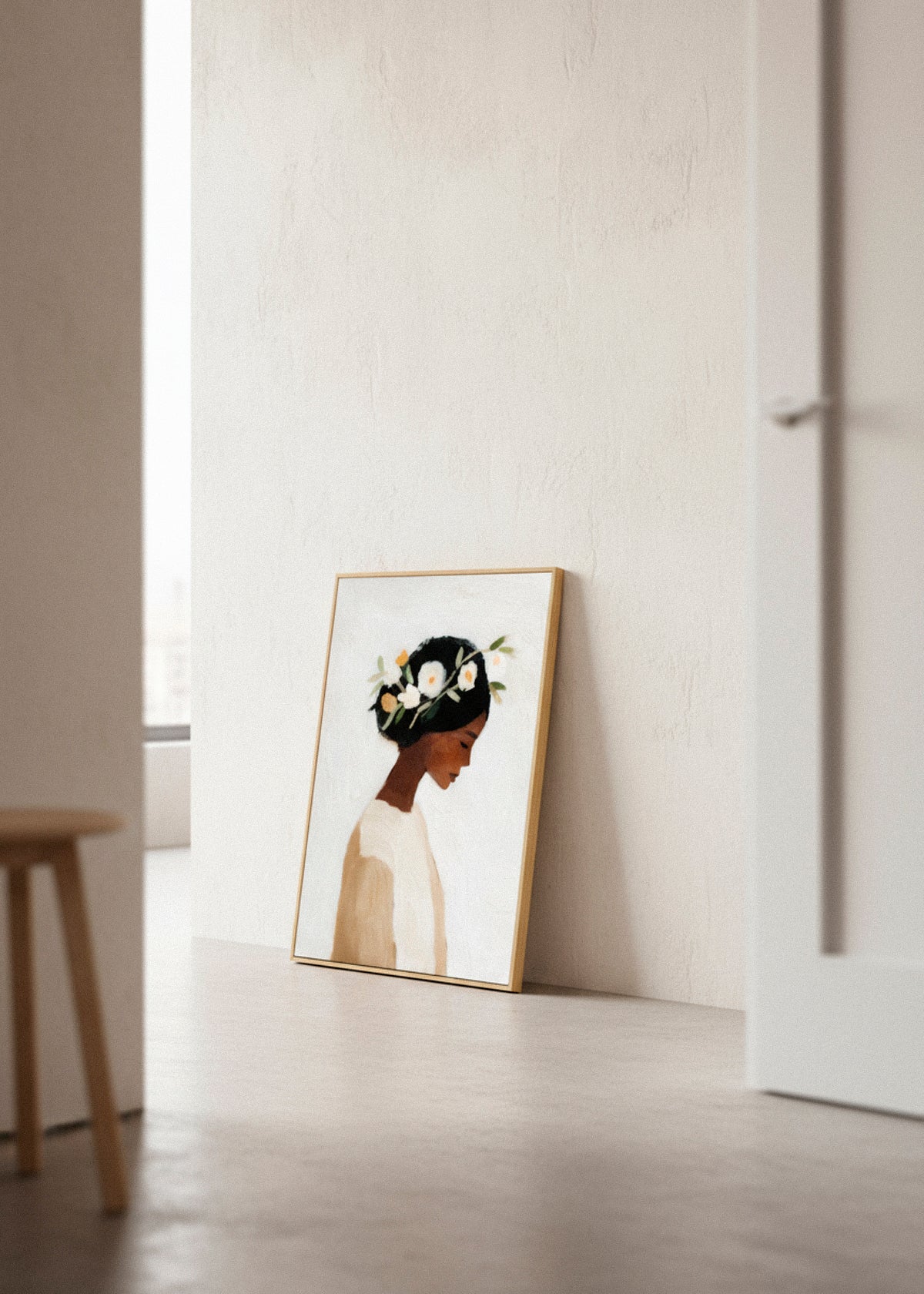 Framed “Saint” canvas print leaning against a soft beige wall in natural light, highlighting the artistic simplicity.