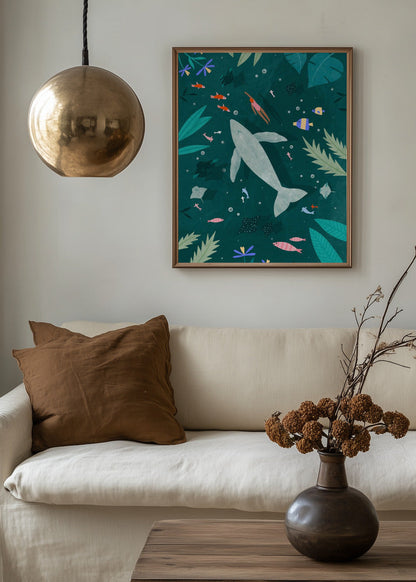 Swimming with a Whale poster by Bea Muller styled above a sofa, featuring a calm underwater scene with whale and swimmer