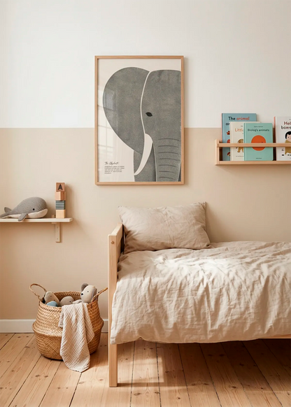 Textured Elephant Wisdom art poster by Ohkimiko displayed above a child’s bed in a soft neutral room with beige bedding, wooden furniture, books and woven storage.