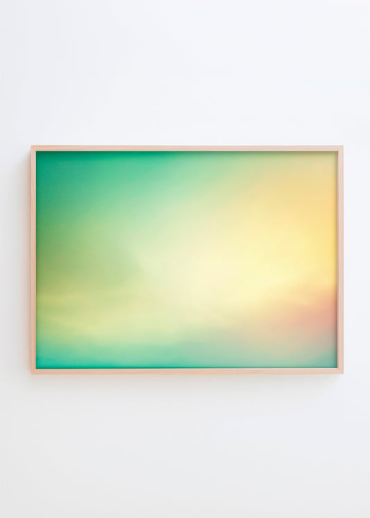 Turquoise gradient poster with smooth color transitions from blue to yellow in a light wooden frame on a white wall.