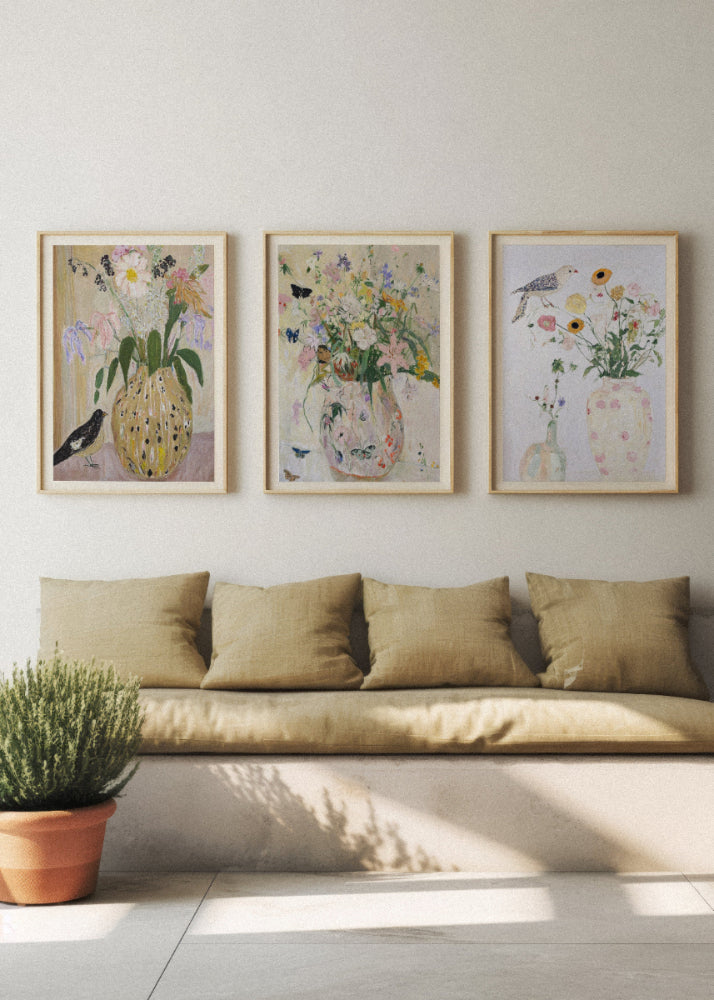 Scandinavian living room with three floral art prints — Bird no. 2, Wild Garden, and Bird no. 1 — framed in light oak above a beige bench, creating a calm and natural home atmosphere.